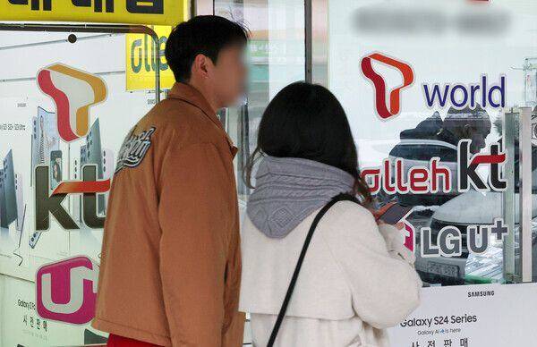 2월 22일 오후 서울의 한 휴대폰 매장 앞으로 시민들이 지나가고 있다. / 뉴스1