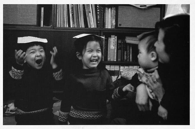 고 전몽각 교수의 자녀인 윤미(왼쪽에서 두 번째)와 남동생이 종이를 모자처럼 머리 위에 올린 채 밝게 웃고 있다. 순간을 포착하기
 위해 급히 찍느라 초점은 나갔지만 해맑은 자녀들의 표정이 좋아 사진집에 수록한 듯하다. 포토넷 제공