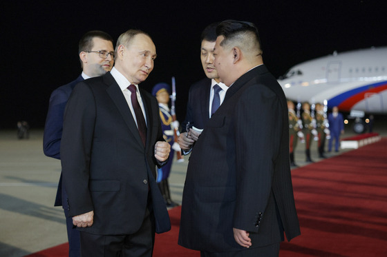 North Korean leader Kim Jong-un welcomes Russian President Vladimir Putin at Sunan Airport in Pyongyang in the early hours of Wednesday. [TASS/YONHAP]