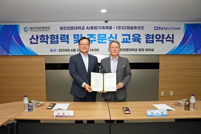 DN솔루션즈 김원종 대표이사(왼쪽)와 영진전문대학교 최재영 총장이 21일 오후 대구 북구 영진전문대학교 본관 회의실에서 산학협력 및 주문식 교육 협약식을 한 뒤 기념 촬영을 하고 있다. [사진제공=DN솔루션즈]