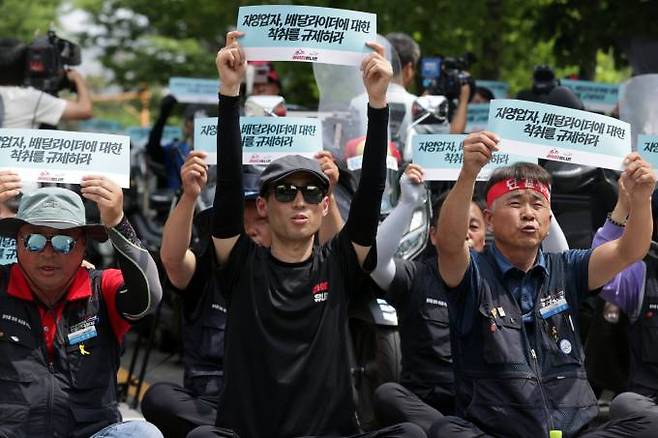 21일 오후 서울 여의도 국회의사당역 2번 출구 앞에서 민주노총 공공운수노조 라이더유니온지부 조합원들이 거대 배달플랫폼 규제를 요구하며 구호를 외치고 있다. 연합뉴스