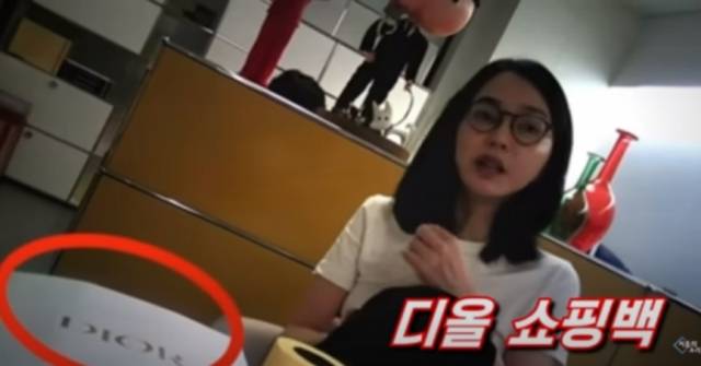 서울의소리가 지난해 11월 공개한 영상에서 김건희 여사가 서울 서초구 코바나컨텐츠 사무실에서 최재영 목사로부터 명품백이 든 쇼핑백을 받아 테이블 위에 올려놓은 장면. 서울의소리 유튜브 캡처