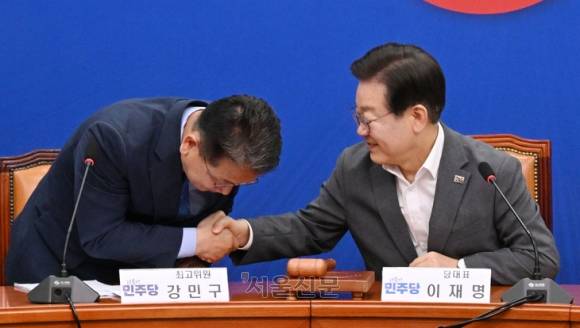 이재명 더불어민주당 대표(오른쪽)가 19일 오전 서울 여의도 국회에서 열린 최고위원회의에 참석해 강민구 최고위원과 악수하고 있다.  안주영 전문기자