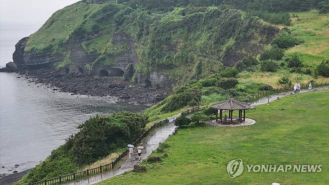 비 내리는 제주 (서귀포=연합뉴스) 박지호 기자 = 비가 내리기 시작한 17일 오전 제주 서귀포시 대정읍 송악산을 찾은 관광객이 산책하고 있다. 2024.6.17 jihopark@yna.co.kr