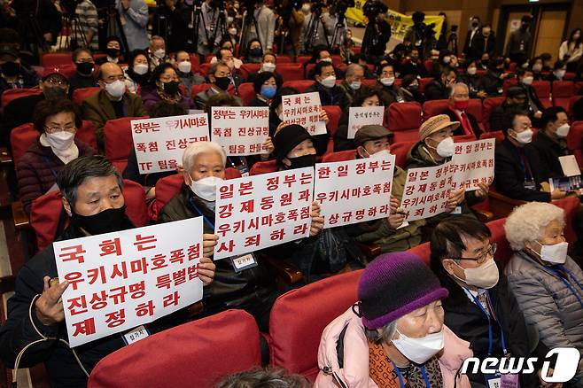 12일 서울 여의도 국회 의원회관에서 열린 강제징용 해법 논의를 위한 공개토론회에서 참석자들이 우키시마호 폭침 진상규명 특별법 제정 촉구 손팻말을 들고 있다. 2023.1.12/뉴스1 ⓒ News1 유승관 기자