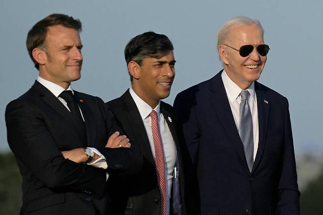 에마뉘엘 마크롱(왼쪽) 프랑스 대통령, 리시 수낙(가운데) 영국 총리, 조 바이든 미국 대통령이 13일 이탈리에서 열린 G7(7국) 회의에 참석해 군인들이 공중에서 강하하는 스카이다이빙 시범을 지켜보고 있다. /AFP 연합뉴스