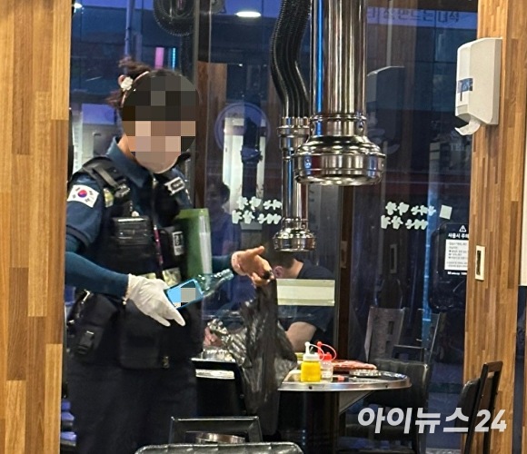 경찰이 B씨가 먹은 술병을 비닐봉지에 담고 있다. [사진=독자 제공]