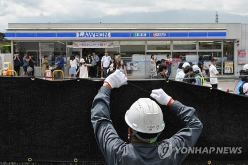 '후지산 편의점' 앞에 가림막 설치하는 인부 (후지카와구치코 AFP=연합뉴스) 지난달 21일 일본 야마나시현 후지카와구치코 마을의 후지산이 배경에 보이는 편의점 앞에 인부가 검은 가림막을 설치하고 있다. 2024.05.21 passion@yna.co.kr