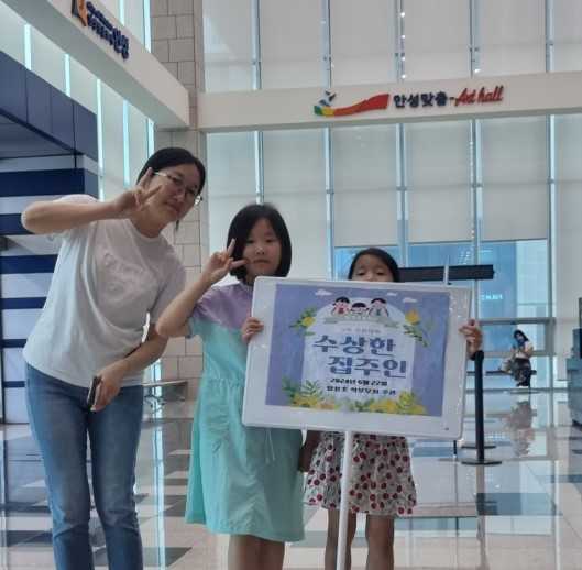 양성초등학교 재학생들이 안성맞춤예술회관에서 가족 문화체험학습을 마치고 피켓을 들고 기념 촬영을 하고 있다. [사진=안성교육지원청]