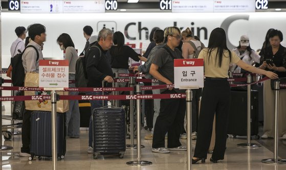 지난 21일 오전 김포국제공항에서 여행객들이 출국 수속을 하기 위해 줄을 서고 있다. [뉴시스]