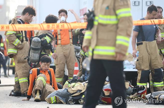 잠시 숨돌리는 소방대원들 (서울=연합뉴스) 류영석 기자 = 24일 경기도 화성시 서신면 소재 일차전지 제조업체 공장 화재 현장에서 실종자 수색 작업이 계속되는 가운데 소방대원들이 더위를 식히며 잠시 휴식을 취하고 있다. 2024.6.24 ondol@yna.co.kr