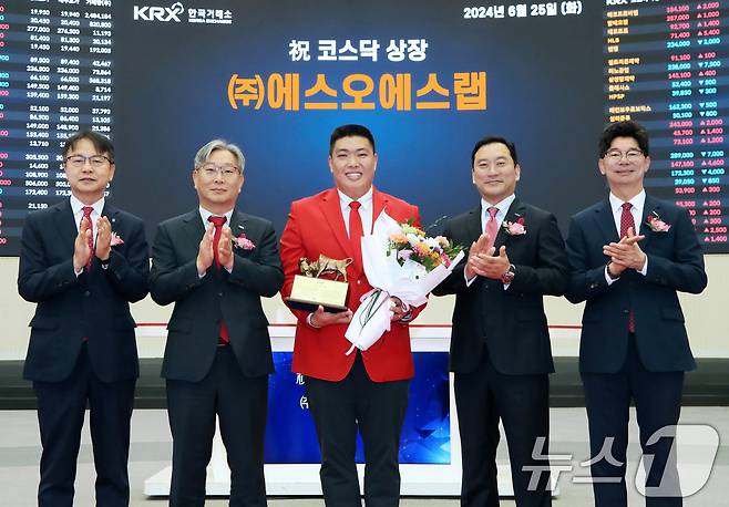 25일 서울 영등포구 한국거래소에서 열린 에스오에스랩 코스닥시장 상장기념식에서 상장기념패 전달 후 김대영 한국IR협의회 부회장(왼쪽부터), 홍순욱 한국거래소 코스닥시장본부장, 정지성 에스오에스랩 대표이사, 김성환 한국투자증권 대표이사, 김준만 코스닥협회 상무가 기념촬영을 하고 있다. (한국거래소 제공) 2024.6.25/뉴스1