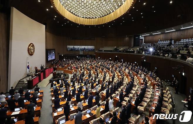 제21대 국회의원들이 16일 오후 국회 본회의장에서 열린 개원식에서 국민의례를 하고 있다. 2020.7.16/뉴스1 ⓒ News1 박세연 기자