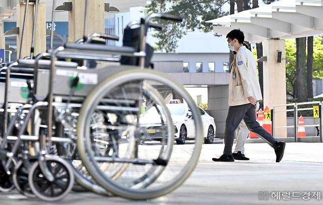 가톨릭대 의과대학 교수협의회 비상대책위원회가 25일 열린 총회에서 무기한 휴진을 당분간 유예하기로 결정했다. 26일 오전 서울 서초구 가톨릭대학교 서울성모병원에서 한 의사가 본관으로 이동하고 있다. 임세준 기자