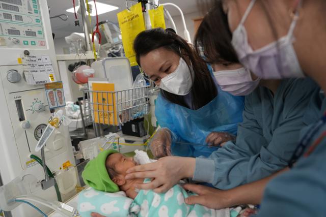 시일레그마 오트공게렐이 24일 분당서울대병원 신생아중환자실(NICU)에서 어렵게 낳은 딸 다쉬제베그 아민후슬렌양을 의료진과 함께 바라보고 있다. 분당서울대병원 제공
