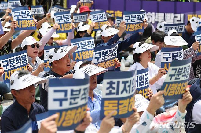 [서울=뉴시스] 권창회 기자 = 소상공인연합회 회원들이 지난 25일 오후 서울 여의도 국회 인근에서 열린 최저임금 제도개선 촉구 결의대회에서 구호를 외치고 있다. 2024.06.27. kch0523@newsis.com