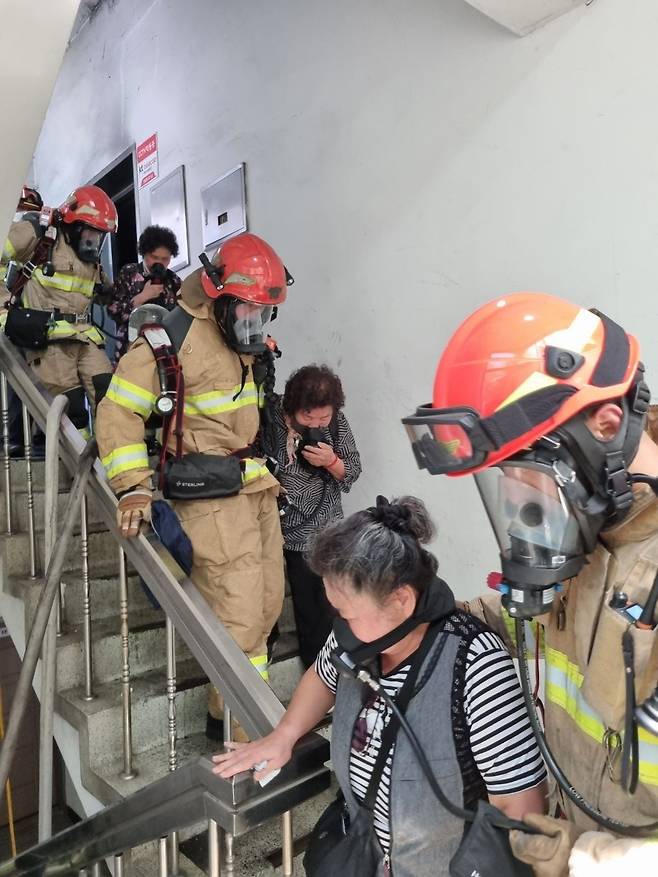 28일 오후 대구 동구 한 복합건물에서 불이나 옥상으로 대피했던 시민들이 소방관의 도움을 받아 건물 바깥으로 나오고 있다. 소방당국은 이들에게 공기 보조마스크를 제공하고, 일대일로 대피시켰다./대구소방안전본부