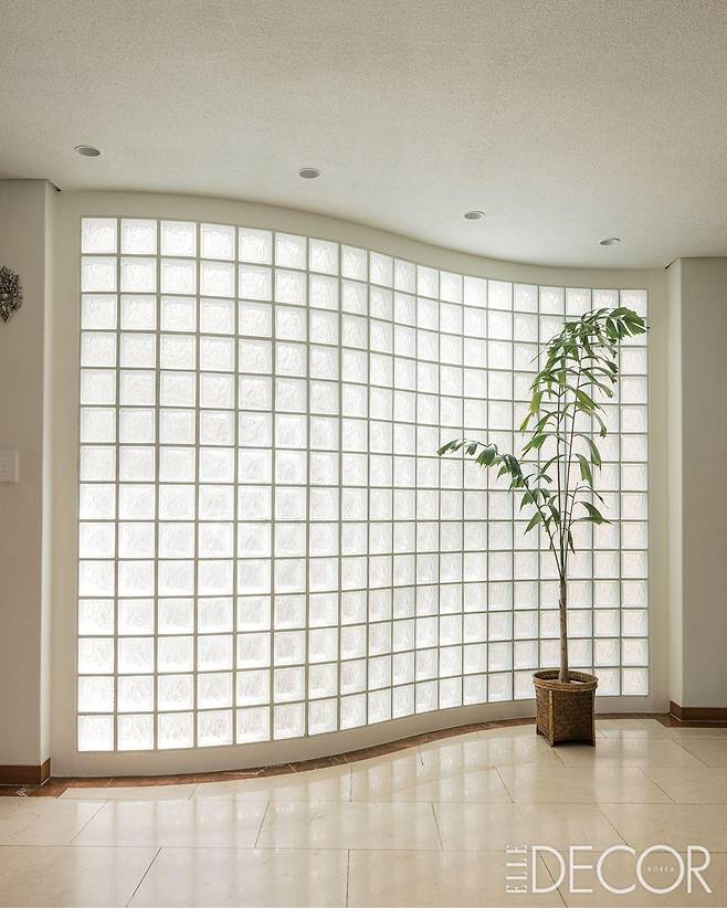 다이닝 룸과 거실을 연결하는 부분에 시공한 유리블록 벽. 튼튼한 기본재들은 최대한 아름다움을 살렸다.