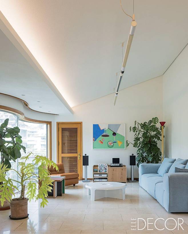 오디오 시스템과 각기 다른 매력의 가구들이 어우러진 거실. 하늘색 소파는 알로소. 1인용 빈티지 체어는 원오디너리맨션에서 구입했다.