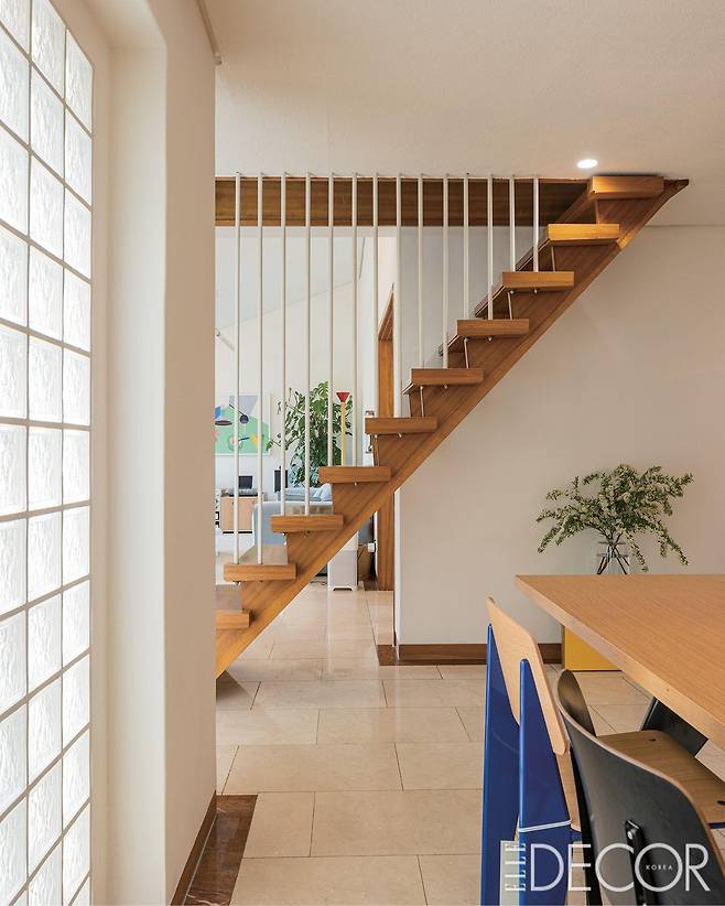 다이닝 룸에서 바라본 나무 계단. 난간이 두껍지 않아 거실까지 시야가 확보된다.