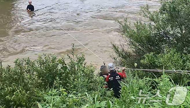 30일 오전 가평군 청평면 조종천 철교하천 중간에 호우로 불어난 물에 고립된 외국인 남성이 소방대원에 의해 구조되고 있다. (경기북부소방재난본부 제공)2024.6.30/뉴스1