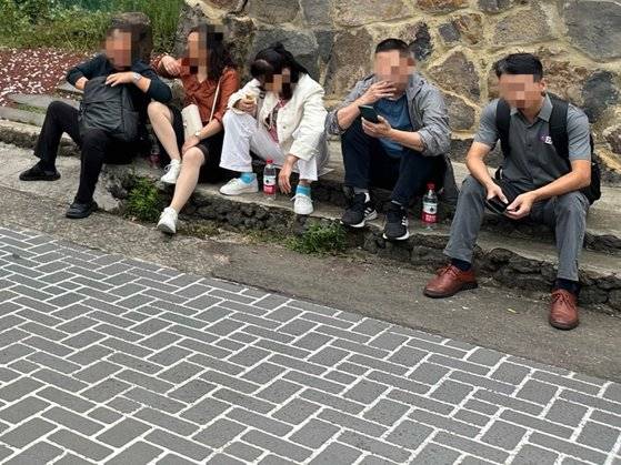 지난 25일 오후 7시 제주시 연동의 한 도로변에서 중국인들이 담배를 피우고 있다. 오른편 바닥에는 담배꽁초가 보인다. 최충일 기자