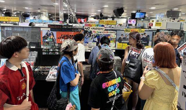 27일 일본 도쿄 시부야 타워레코드의 뉴진스 앨범 판매대 앞에서 손님들이 기념사진을 찍는 등 둘러보고 있다. 도쿄=고경석 기자