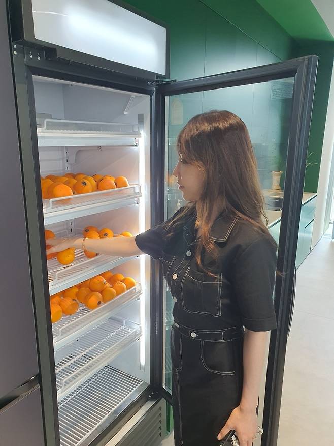 김소정 대리가 6층 카페 앞 냉장고에서 무료로 제공되는 오렌지를 꺼내고 있다. 윤현주 기자