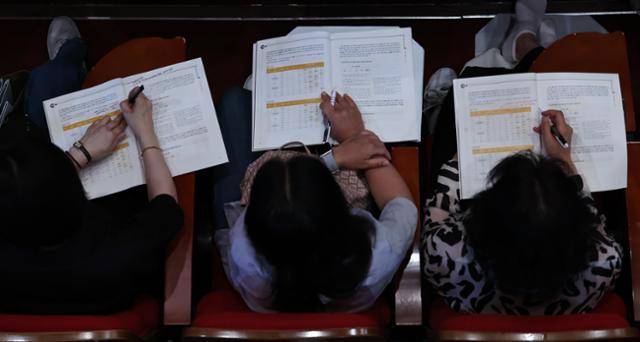 15일 서울 광진구 세종대에서 열린 EBS-한국대학교육협의회 주최 2025학년도 입시설명회에서 학부모들이 입시 자료집을 살펴보고 있다. 뉴스1