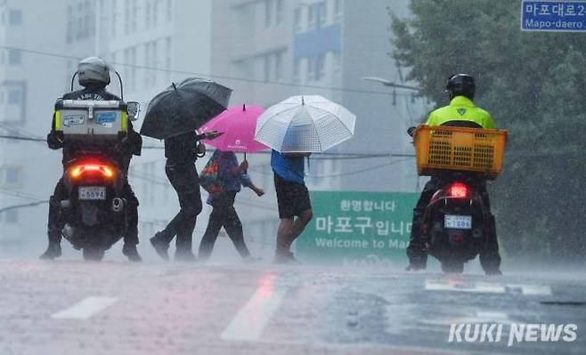폭우가 내리는 가운데 2일 오전 중구 만리동 고개 횡단보도를 시민들이 건너고 있다.