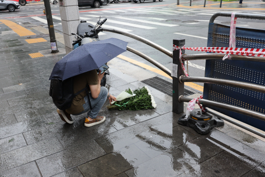 2일 오전 지난밤 대형 교통사고가 발생한 서울 중구 시청역 7번 출구 인근 사고 현장에서 한 시민이 국화꽃을 놓고 있다.  1일 밤 역주행하던 승용차가 인도로 돌진해 9명이 숨지고 4명이 다치는 사고가 발생했다. 연합뉴스