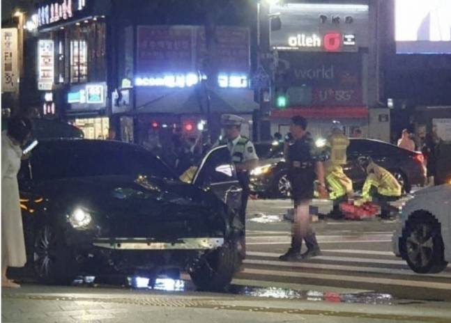 사고 직후 차량을 확인하는 가해운전자 부인 김씨가 흰 옷을 입고 있는 모습. [온라인 커뮤니티]