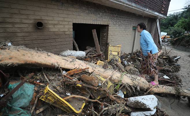 지난해 7월 16일 오전 경북 예천군 감천면 벌방리에서 한 주민이 산사태로 부서진 집을 살펴보고 있다. [연합]