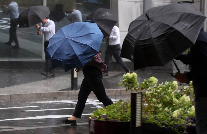 오는 4일 목요일은 밤부터 전국 대부분 지역에 강하고 많은 비가 내리겠다. 돌풍과 함께 천둥·번개도 치겠다. 사진은 장마가 시작된 지난 2일 서울 영등포구 여의도역 인근에서 우산을 쓴 시민들이 이동하고 있는 모습. 뉴시스