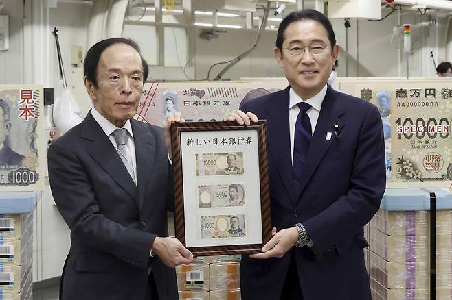기시다 후미오(오른쪽) 일본 총리가 3일 일본 도쿄의 일본중앙은행(BOJ)에서 우에다 가즈오 BOJ 총재와 함께 새로 발행한 지폐 3종을 들고 기념 촬영하고 있다. 최고액권인 1만 엔(약 8만6000원)에는 한국 경제 침탈의 주역인 '시부사와 에이이치'의 초상화가 들어가 논란이 일고 있다. 2024.07.03. /AP=뉴시스