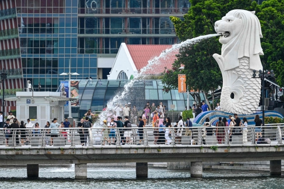싱가포르의 랜드마크인 머라이언 파크의 사자상 주변을 시민들과 관광객들이 걷고 있다. 2024.5.13 AFP 연합뉴스