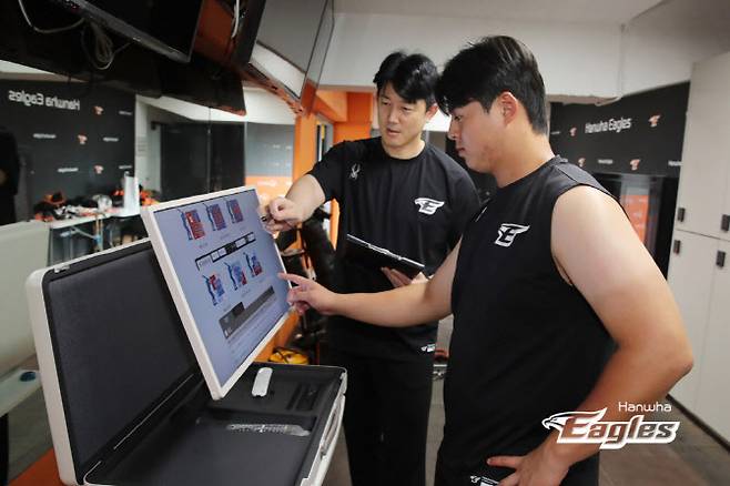 한화이글스 노시환이 이동식 스마트TV를 통해 전력분석원과 함께 훈련 데이터를 체크하고 있다. 사진=한화이글스