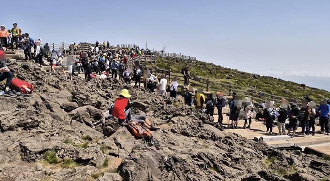 한라산 정상 ‘백록담’ 정상석에서 인증 사진을 찍으려는 사람들이 줄지어 서 있다. (사진=제주도 한라산국립공원관리소 누리집 캡처)