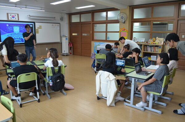 의령교육지원청 '공유교육' 동부권 거점학교인 부림초등학교에서 부림초교, 부림초교 봉수분교장, 유곡초교, 낙서초교 학생들이 수업을 함께하고 있다. 4학년 학생들이 모둠을 만들어 앉아 코딩을 배우는 모습. 담임교사 한 명이 주된 설명을 하고 다른 교사들은 개별 지도를 하고 있다. /이동욱 기자 