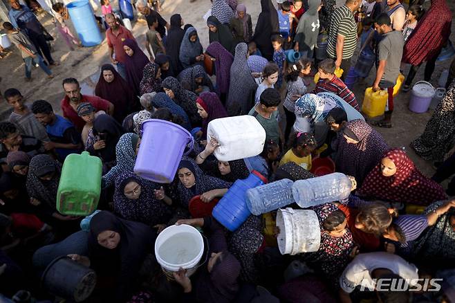 [칸유니스=AP/뉴시스] 이스라엘의 가자지구 폭격과 대피 명령으로 몇 차례씩 피난을 거듭하며 난민이 된 팔레스타인인들이 칸유니스의 임시 텐트촌에서 식수를 받기 위해 대기하고 있다. 2024.07.04.