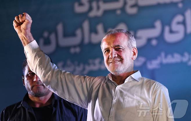 이란 대통령 선거 결선투표를 이틀 앞둔 3일(현지시간) 테헤란의 한 경기장에서 선거 유세를 하는 개혁파 후보 마수드 페제시키안이 주먹을 높이 들어 올리고 있다. 2024.07.03. ⓒ AFP=뉴스1 ⓒ News1 조유리 기자