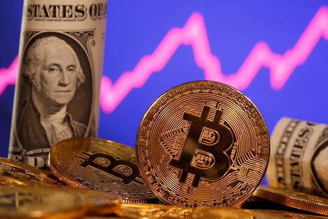 FILE PHOTO: A representation of virtual currency Bitcoin and U.S. One Dollar banknote are seen in front of a stock graph in this illustration taken January 8, 2021. REUTERS/Dado Ruvic/File Photo