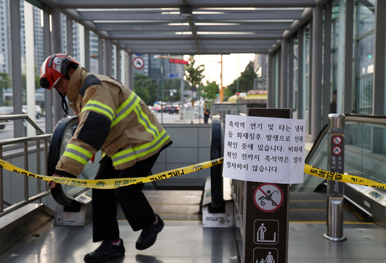 Firefighter restricts access to Heukseok Station in eastern Seoul on Monday afternoon as smoke appeared with an unidentifiable reason. [YONHAP]