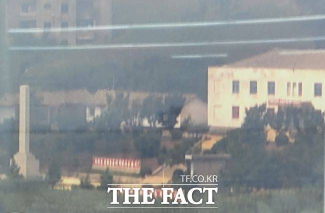 북한 개풍군 선전마을에 북한 체제를 찬양하는 붉은 색 바탕의 홍보물이 애기봉 조강전망대 망원경을 통해 선명하게 보인다. /유명식 기자