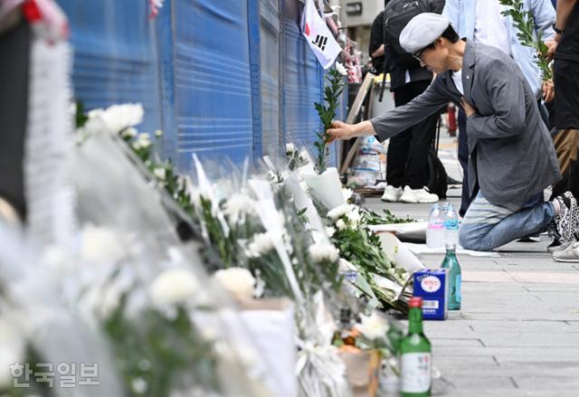 3일 서울 중구 시청역 교차로 인근에서 발생한 차량 인도 돌진 사고 현장에 고인들을 추모하는 추모 용품들이 놓여 있는 가운데 한 추모객이 국화꽃을 놓고 있다. 왕태석 선임기자