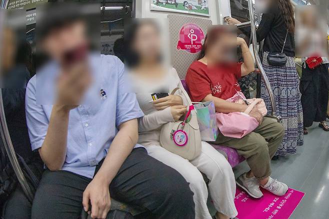 지난 4일 오후 서울지하철에서 일반 승객이 임산부 배려석에 앉아 있고, 정작 임산부는 일반석에 앉아 있다. 사진 속 임산부(가운데 흰옷 여성)는 배려석에 앉지 못하고 서 있다가 일반석에 자리가 나자 그제야 앉을 수 있었다. /박성원 기자