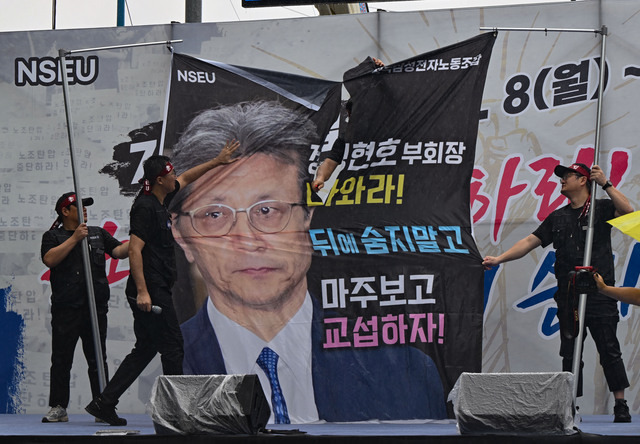 전국삼성전자노동조합이 8일 경기도 화성 삼성전자 화성사업장 앞에서 총파업 결의대회를 열고 정현호 부회장이 담긴 현수막을 찢고 있다. 화성=윤웅 기자