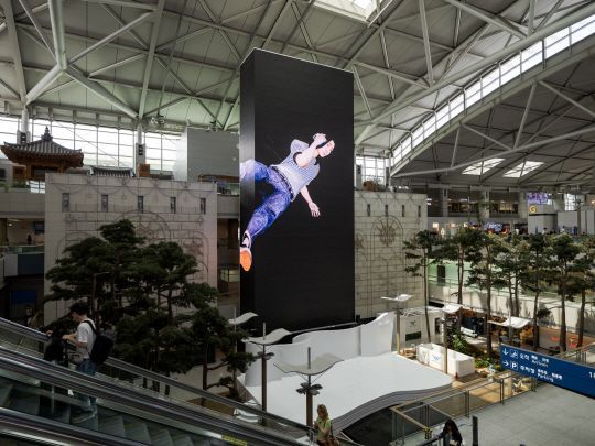 인천공항 제1터미널의 대형미디어타워. 김희천 작가의 ‘더블포져’ 가 설치된 모습. [사진제공 =  예술경영지원센터]