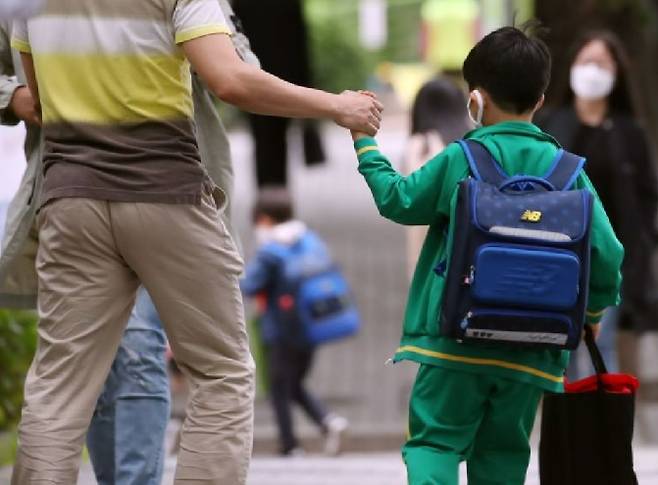 초등학교 예비소집에 아버지와 손을 잡고 들어가는 초등학생 모습. [연합]