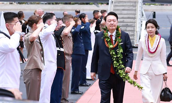 윤석열 대통령과 김건희 여사가 8일(현지시간) 북대서양조약기구(NATO·나토) 75주년 정상회의 참석에 앞서 미국 하와이 히캄 공군기지에 도착, 환영 꽃목걸이를 받고 의장대 사이로 걷고 있다. 연합뉴스